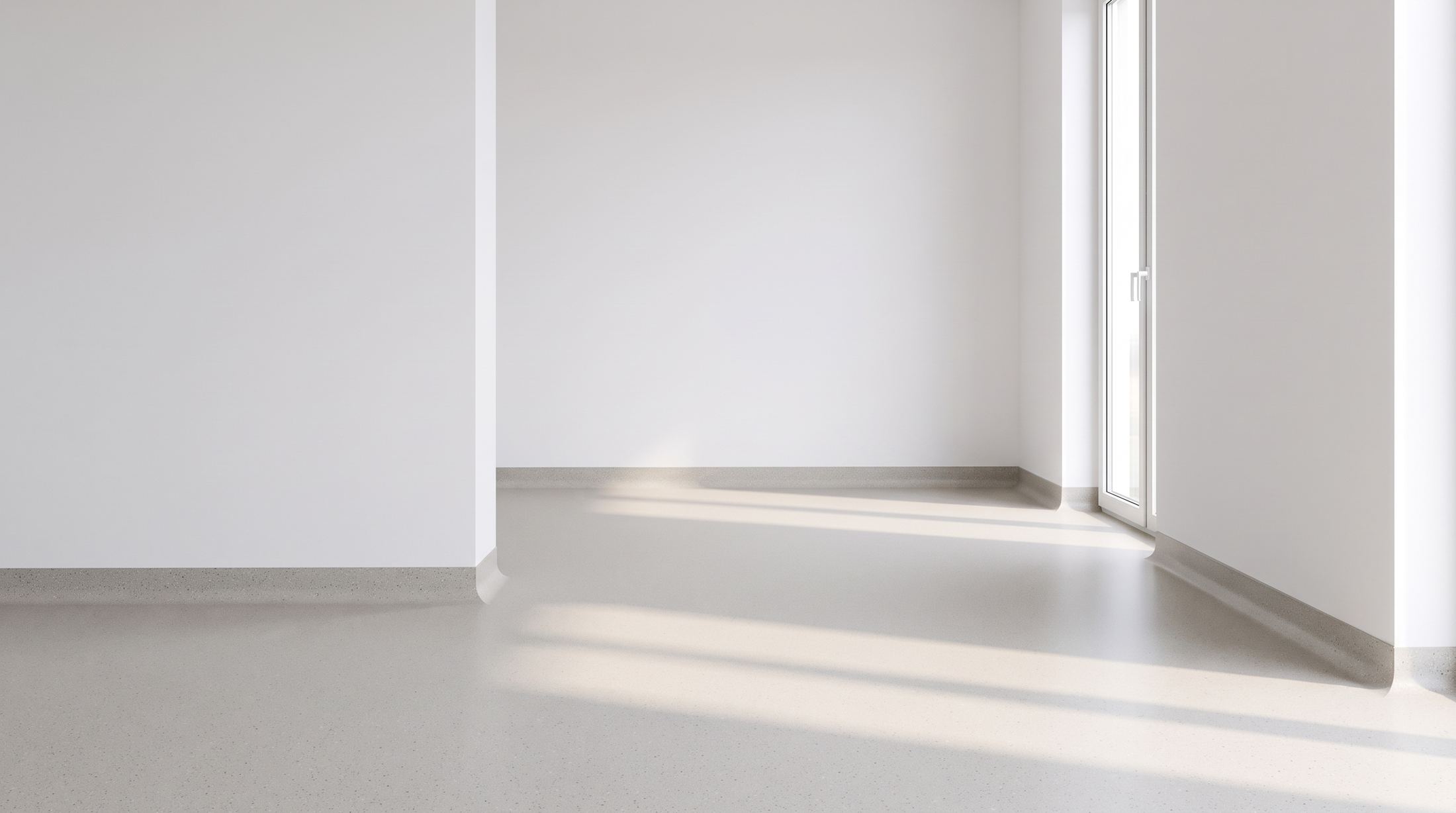 A bright room with welded light grey sheet vinyl curving up the walls