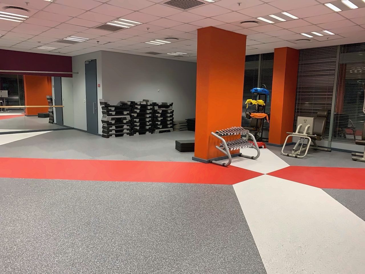 A gym floor laid by Miccor Flooring, grey with red and white bands