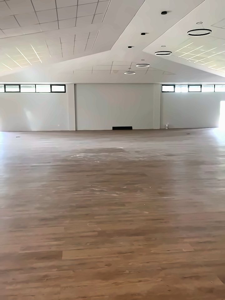 A large empty hall with a wood-look plank floor